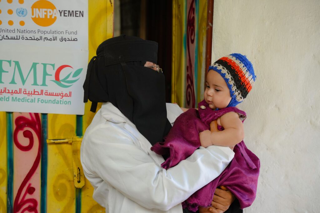 20 Community Midwives in Yemen Bringing Essential Care Closer 5 Community midwife Saba Ali Saleh holding a newborn baby in Al-Shaab village, Yemen